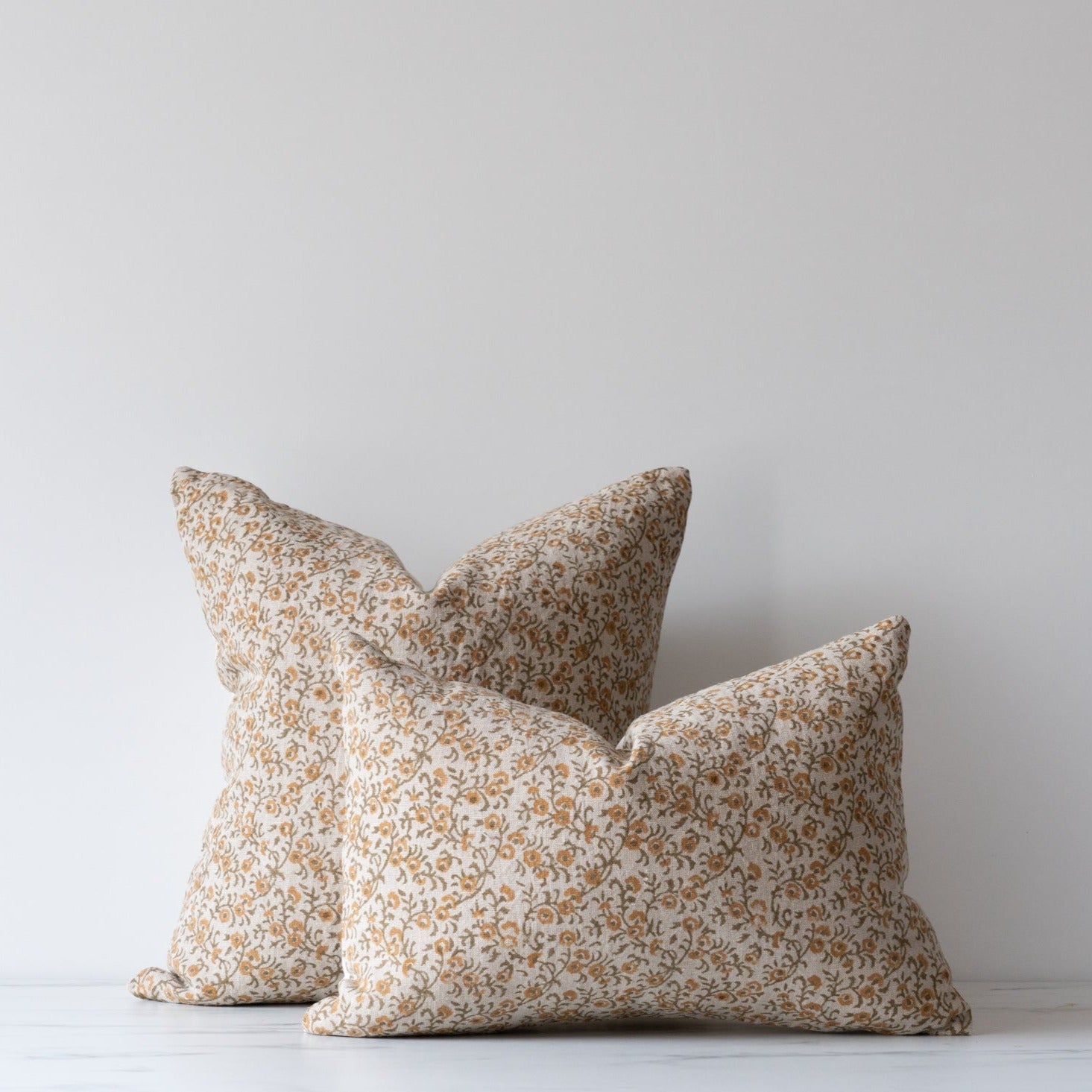 Square and lumbar pillows with small floral block print in green and soft apricot.