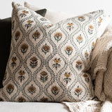 Floral block print pillow cover featuring green vines and ochre flowers on beige linen background.