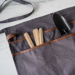 Grey utility apron with garden accessories